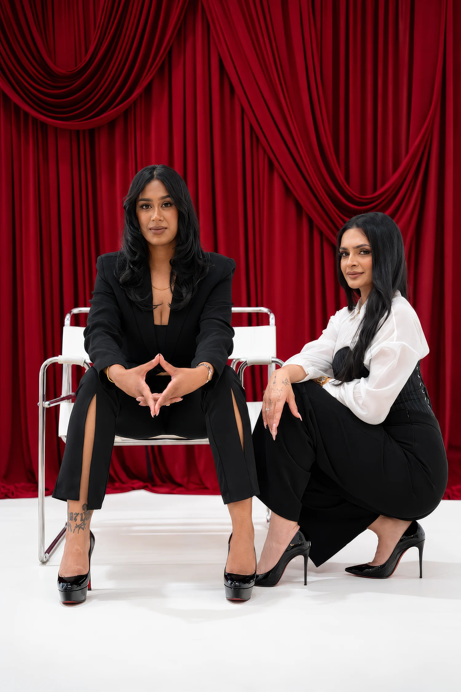 The founders of Chai & Spice photographed against a red velvet curtain